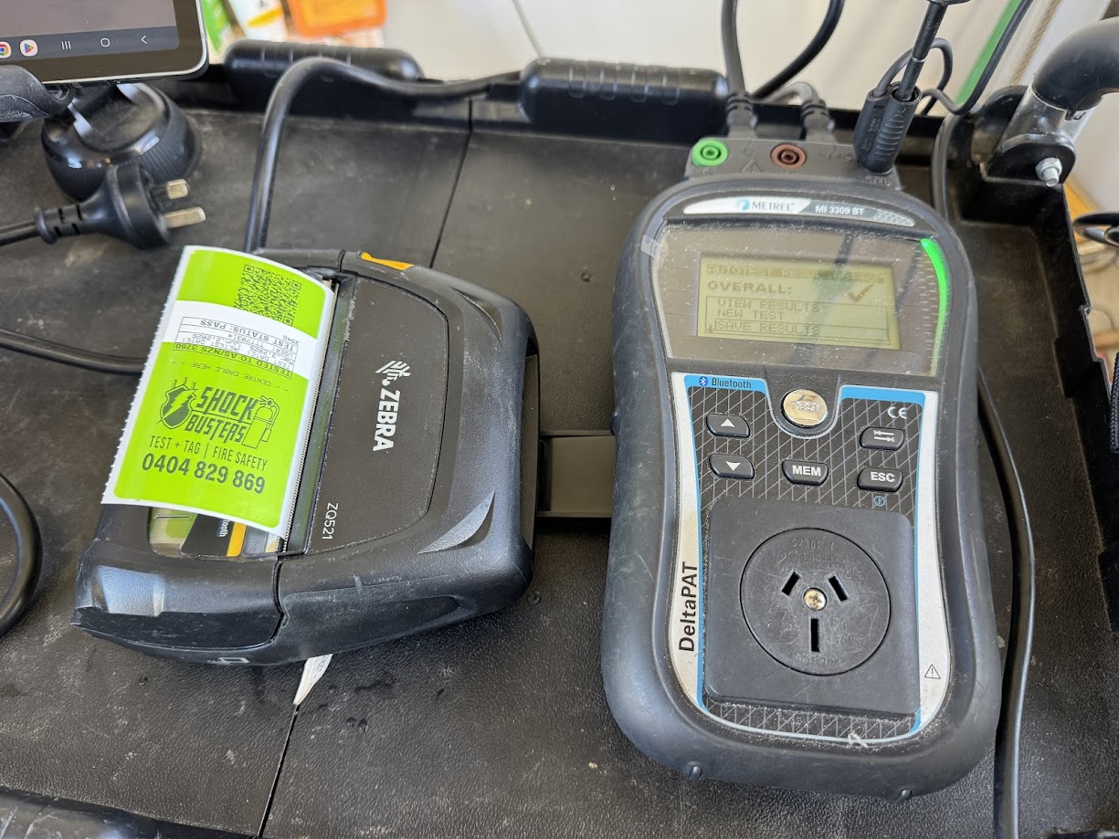 PAT tester applying a Shock Busters electrical test tag during AS/NZS 3760 testing in NSW